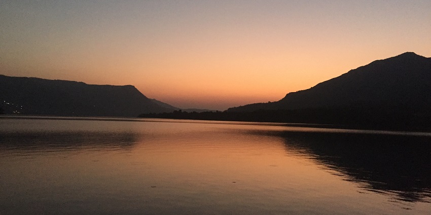 Mulshi Lake in Maharashtra is one of the offbeat places near Pune, surrounded by hills and greenery under a cloudy sky