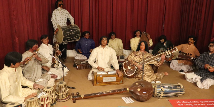 A picture taken at a wax museum with sculptures of musical instrument players