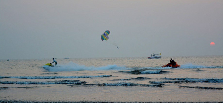 Nagaon Beach with golden sand and people enjoying the sun and surrounding water.