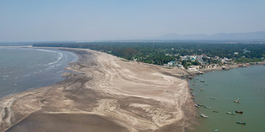 An aerial view of the Randha Falls featuring golden sands and cobalt blue waters.