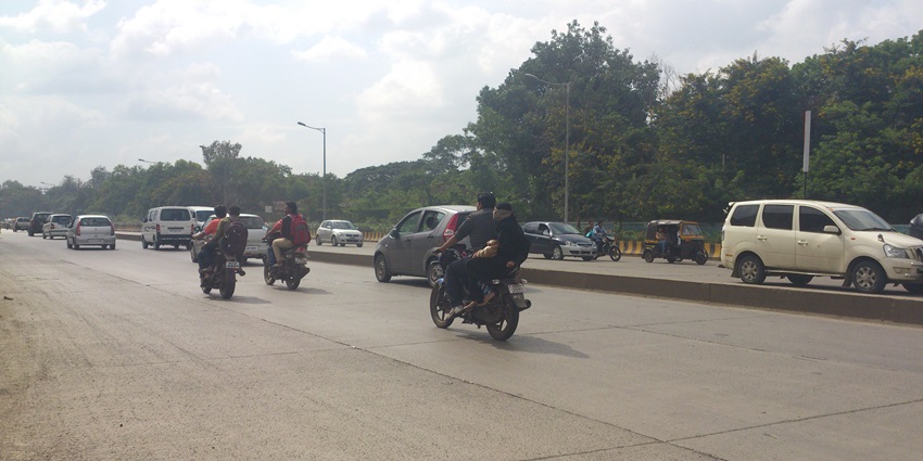 A bustling view of a road with vehicles near Lohegaon Water Park