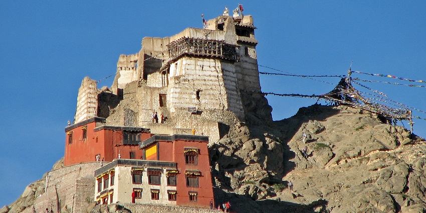 A picture of a Gompa located in Leh, on top of a tall hill