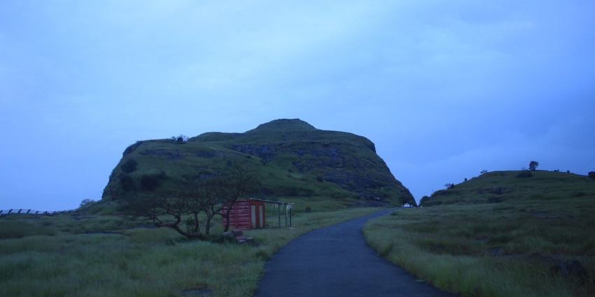 A scenic view of Naneghat hills with lush greenery, a famous tourist attraction near Manmodi.