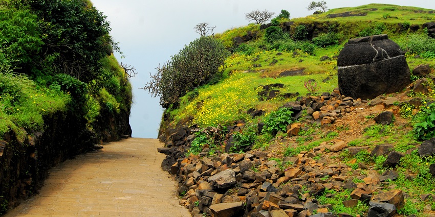 Tourist view of Naneghat Pass, surrounded by hills, near the waterfalls in Maharashtra.