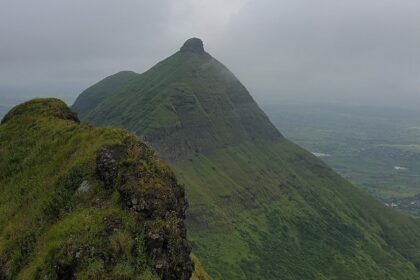 Panoramic view of Achal Fort in Nashik, showcasing its rugged landscape and stone walls.