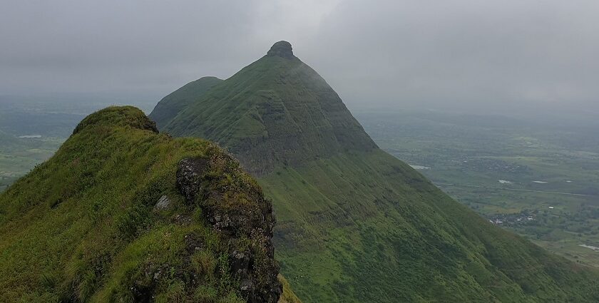 Panoramic view of Achal Fort in Nashik, showcasing its rugged landscape and stone walls.