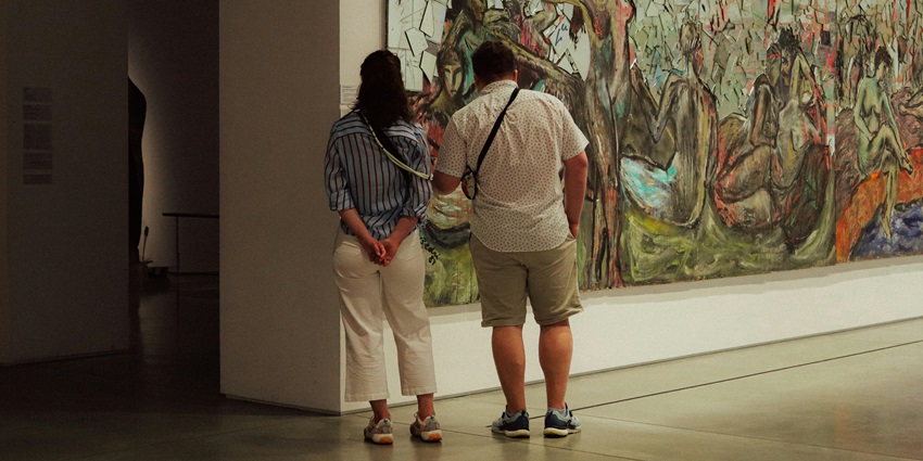 Visitors viewing modern Indian art at NGMA hall, one of the places to visit near the Iskcon temple, Bangalore.