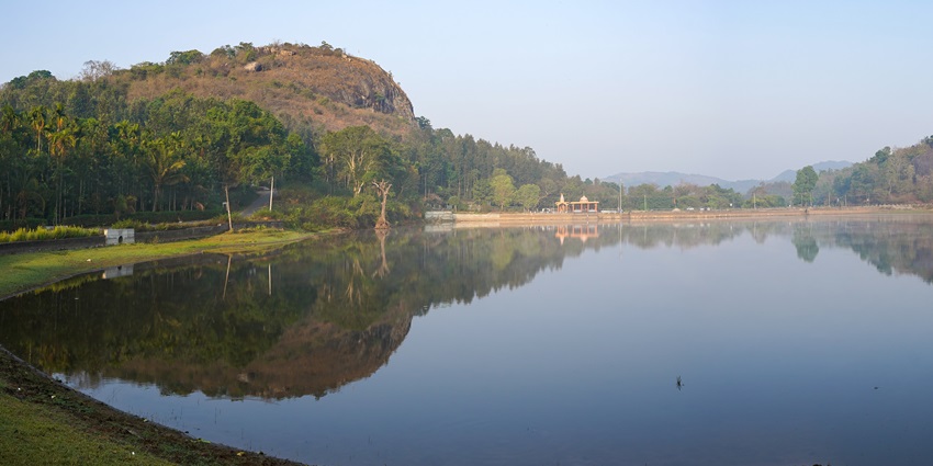 Panoramic view of the Honnamana Kere Lake, set amidst a lush green landscape of Coorg