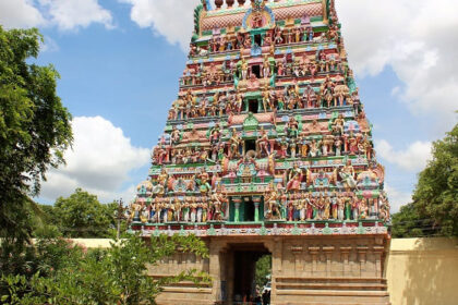 A temple, showcasing its intricate architecture and traditional design with blue sky behind.