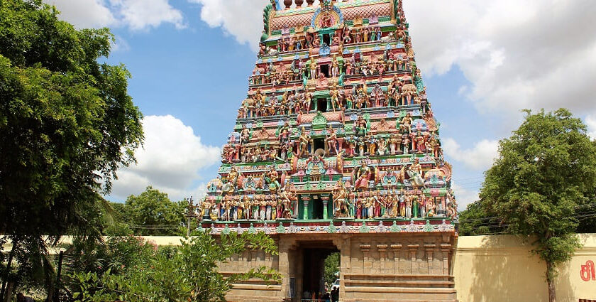 A temple, showcasing its intricate architecture and traditional design with blue sky behind.