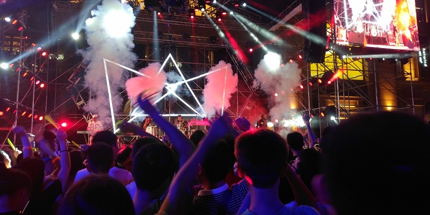 An image of a lively rave set in a bustling night market atmosphere in Bangkok.
