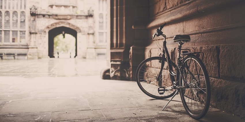 Image of a bicycle leaning against a grungy urban wall.