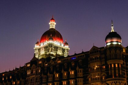 A beautiful picture of a hotel taken during nighttime, lit up with lights up the dome