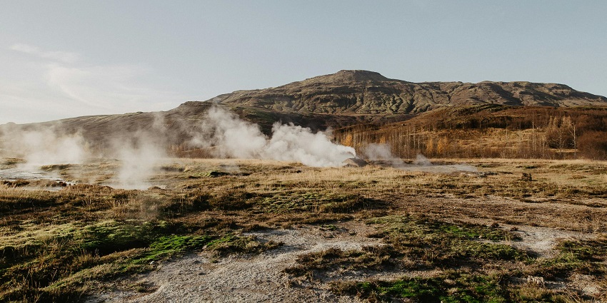 View of the steams rising from the hot springs with panoramic views of the hills around