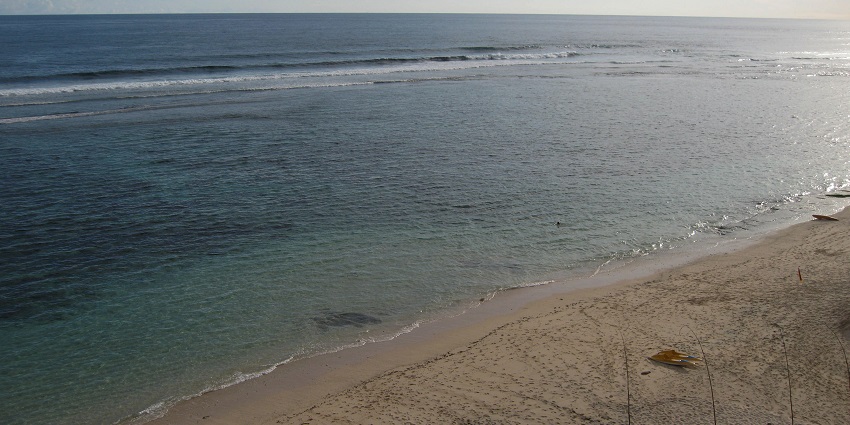 A distant view of Nyang Nyang Beach on whose shore there are three yellow boats