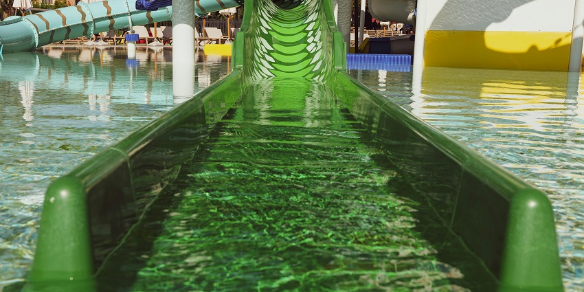Colourful water slide at an Ocean Blue Water Park with excited visitors ready to dive in