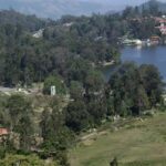 View of Kodaikanal Lake surrounded by hills and trees in Kodaikanal.