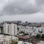 A shot of the Pune skyline with modern buildings and greenery during the day