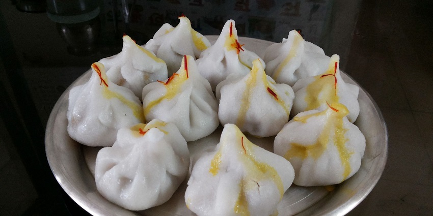A plate full of momo-like looking sweets used as a prasad at the Siddhivinayak Temple