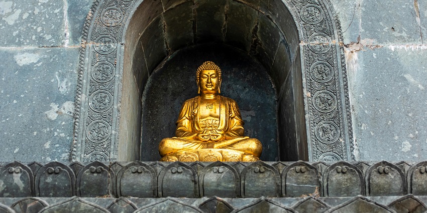 Buddha statue nestled in a charming red brick shrine, reminiscent of Buddha Cave