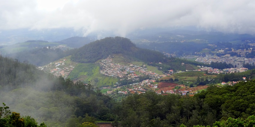 A picture of the scenic hill station of Ooty with verdant valleys and a cover of mist in the air