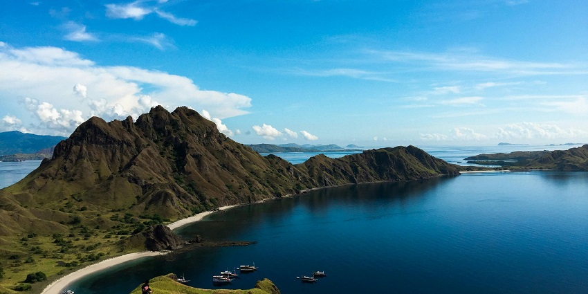View of verdant hills and a serene water body amidst on Komodo island