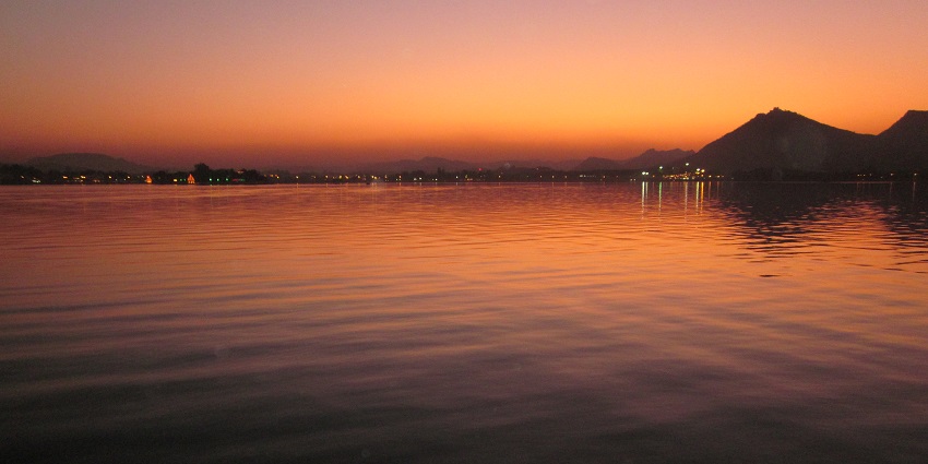The sky and the water have become orange in Fateh Sagar Lake, Udaipur, during sunset