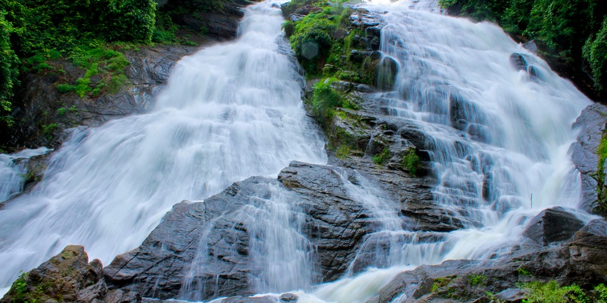 The breathtaking Vajrai Waterfalls flowing down a mountain, framed by greenery and rocky terrain.