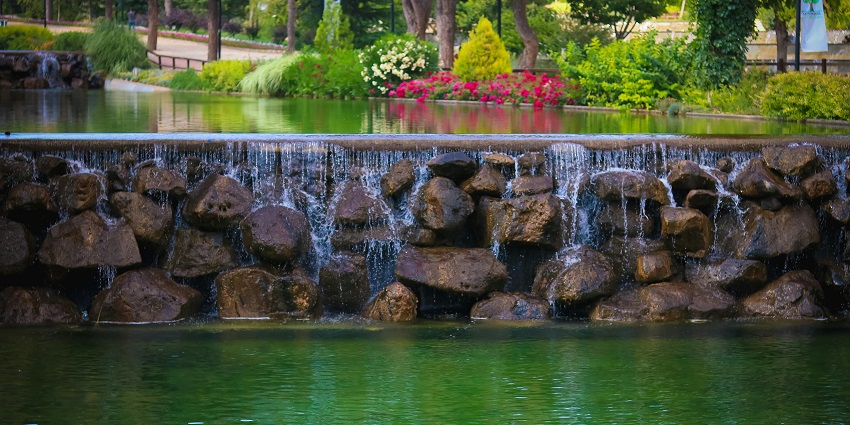 A tranquil body of water reflecting the sky and surrounded by greenery.