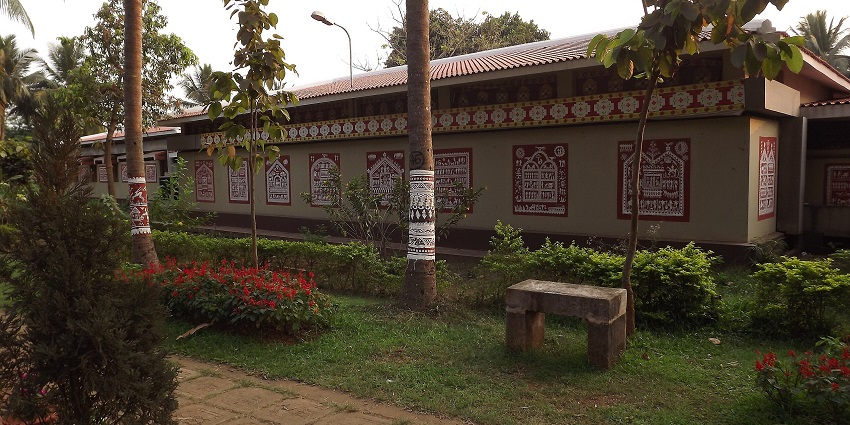 A view of traditional tribal paintings on the walls of the museum in the lush green surroundings
