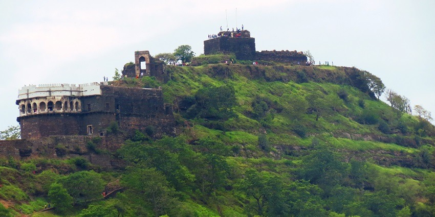 Distant view of the fort surrounded by greenery and walls covered with moss