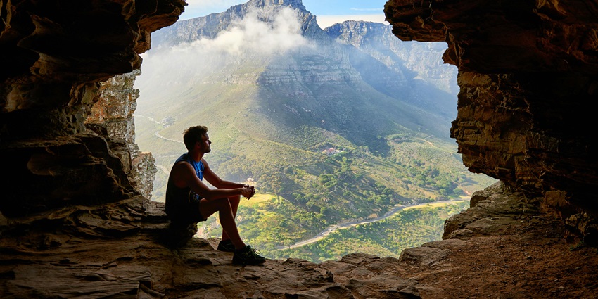 A view of a dark cave with a distant view of the sky through the cave opening in Maharashtra.