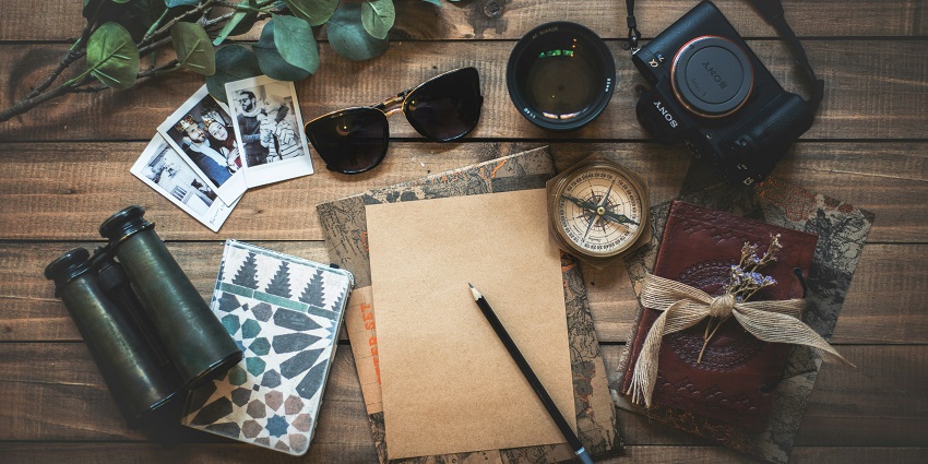 Essential travel items for a wildlife sanctuary include binoculars, a camera, and a field guide.