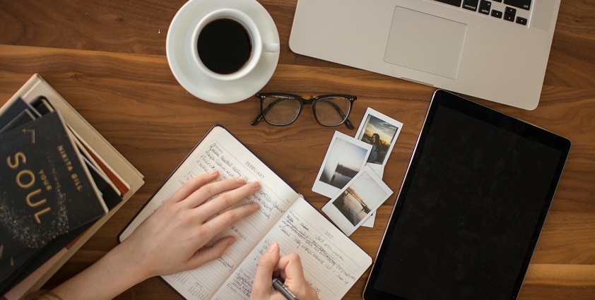 An image of travel things - a diary, a camera, suitable clothing and many more.