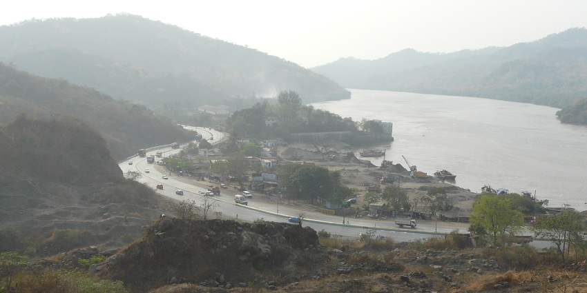 Aerial view of Ghodbunder Road with vehicles and greenery lining the road.