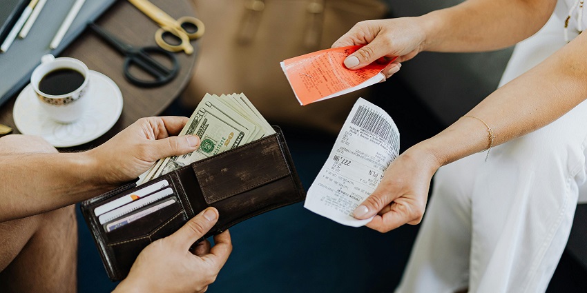 A picture of a person paying bills at an aesthetic cafe near Lempuyang Temple.