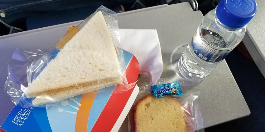 Meal with a sandwich, cake, and a bottle of water as tips for visitors.