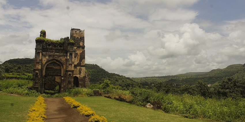 Hilltop fortress surrounded by rugged landscape under a clear blue sky in Maharashtra