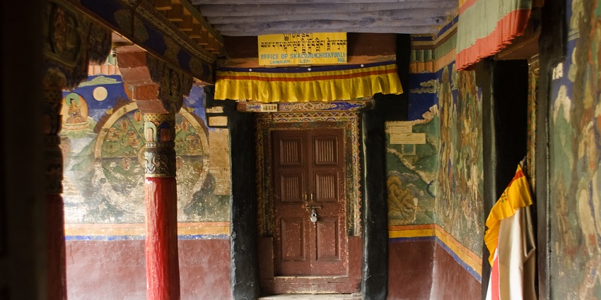 A picture of a temple door in Ladakh with Tibetan language written on it