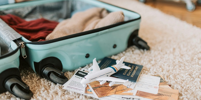Black and green luggage bag resting on a brown carpet, ready for travel.