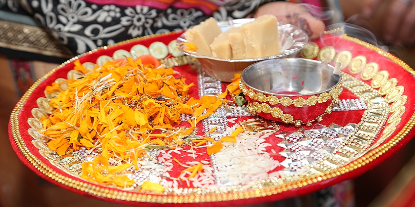 mage of a pooja thali with flowers and sweets on the plate for rituals