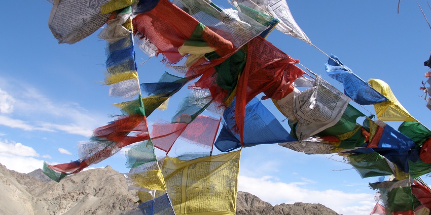 An image of the prayer flags with Tibetan writing on them hanging around in Ladakh.