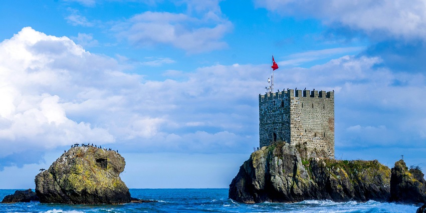 An image showing a majestic brick castle by a beautiful body of water, reminiscent of Gorakhgad Fort