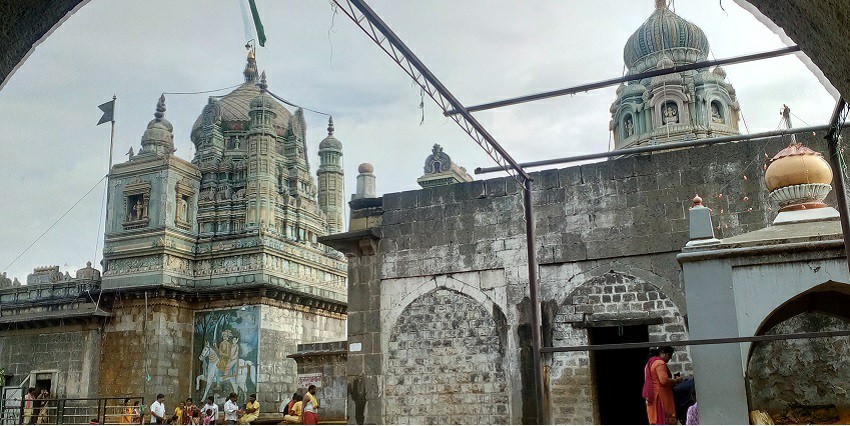 View of the large temple building with tourists walking in and out
