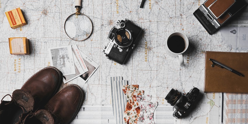 An image of travel things - a diary, a pair of comfortable shoes, and many more.