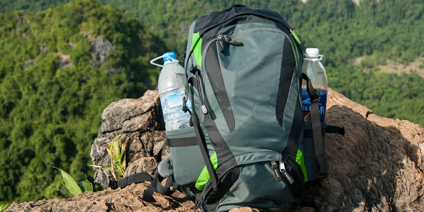 A durable trekking backpack loaded with gear against a scenic mountain backdrop.