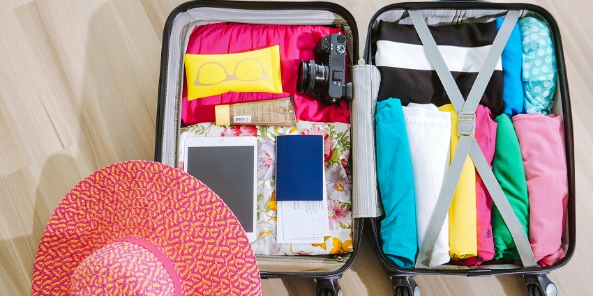A packed suitcase ready for travel, organised with clothes and essentials.