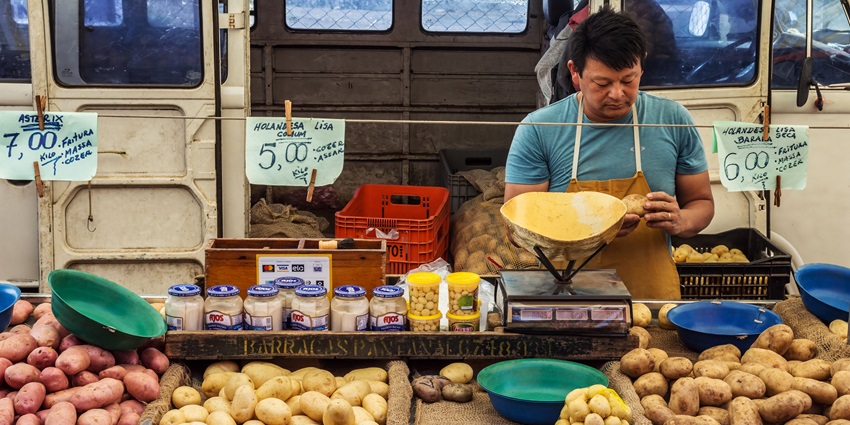 Snapshot of a man selling its vegetables in the vicinity of a daily market in the city