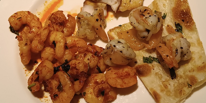 Delicious prawns with buttery naan on a white plate in a restaurant in JW Marriott.