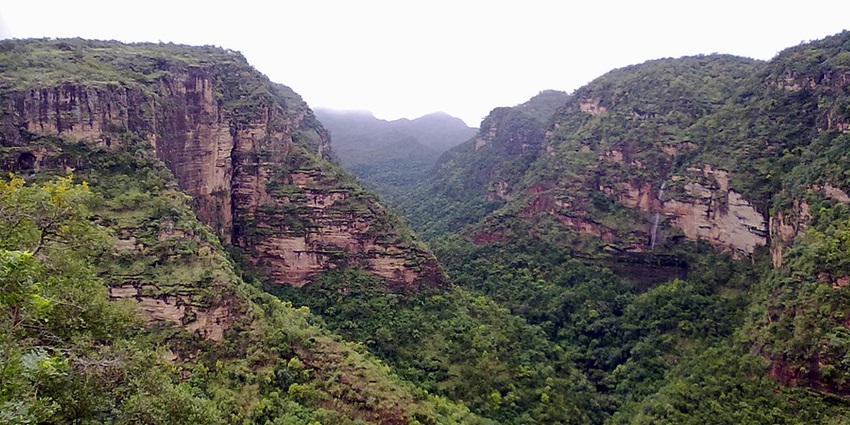 A scenic view of Pachmarhi Valley, showcasing lush green hills and blue skies